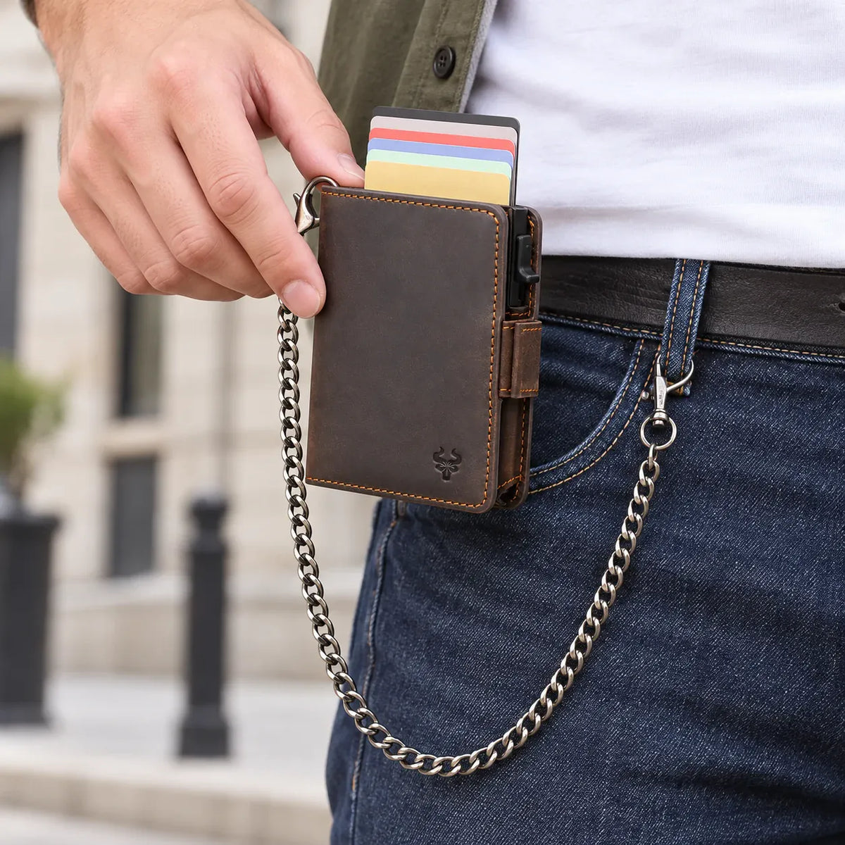 Aubervilliers — porte-cartes café brun foncé tenu en main, avec sa chaîne