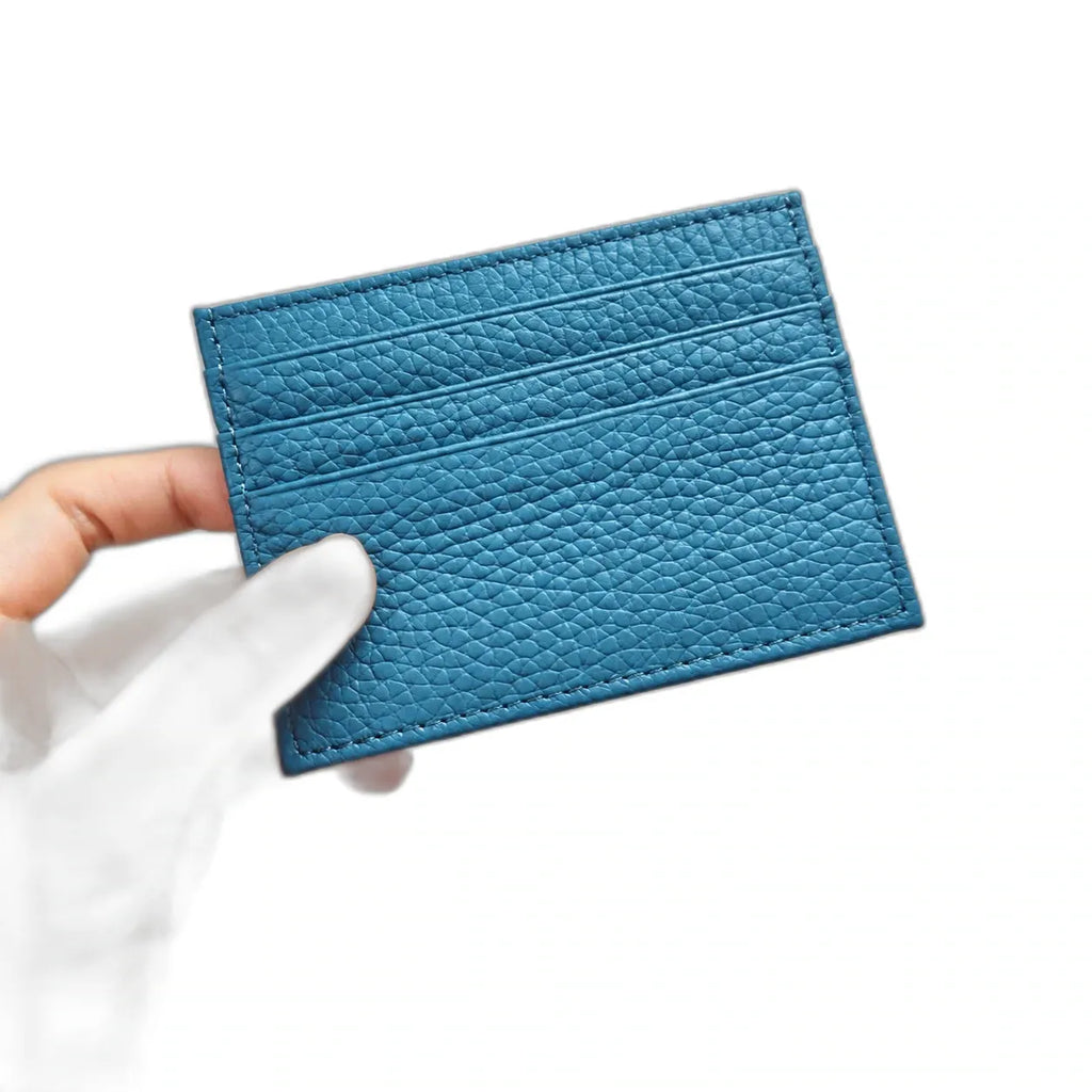 Nouméa — porte-cartes bleu denim tenu en main