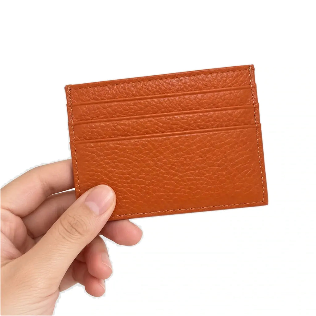 Nouméa — porte-cartes orange tenu en main