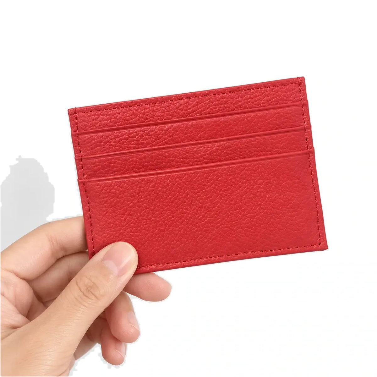 Nouméa — porte-cartes rouge tenu en main