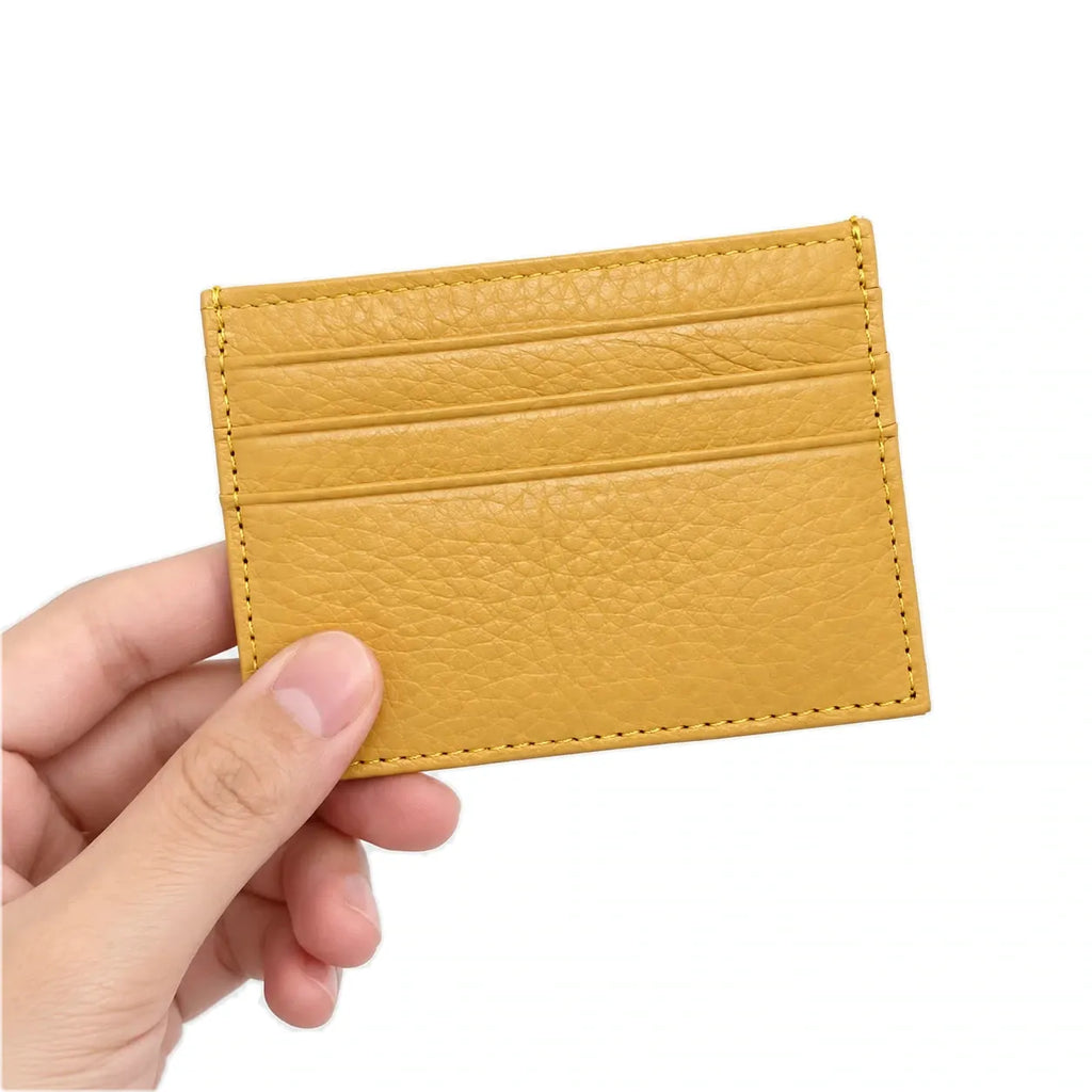 Nouméa — porte-cartes jaune tenu en main